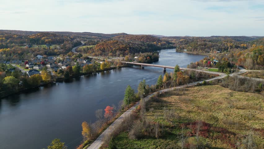 Aerial view of colorful autumn trees and road in the autumn forest taken from drone height.