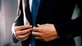 Business man buttoning or unbuttoning his expensive suit jacket. Making business suit looks good. Getting ready for work. Formal suit and a young man. - Powered by Shutterstock - Get 15% off with code: PIKWIZARD15