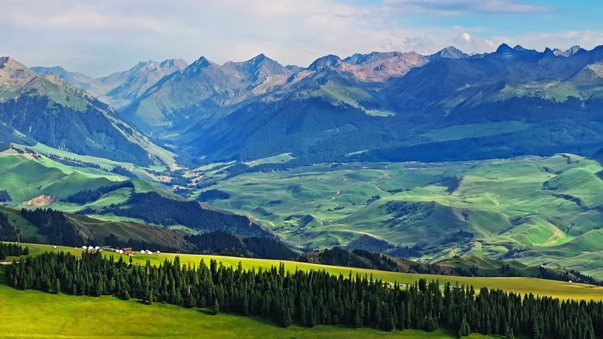 Green grass and forest with mountain natural landscape in Kalajun grassland, Xinjiang. Kalajun Grassland is one of the most famous grasslands in China.