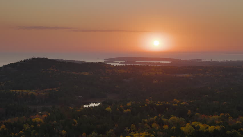 Bright sun rises over the vast forest on the shore on Lake Superior. Shot near Marquette, MI in 4K