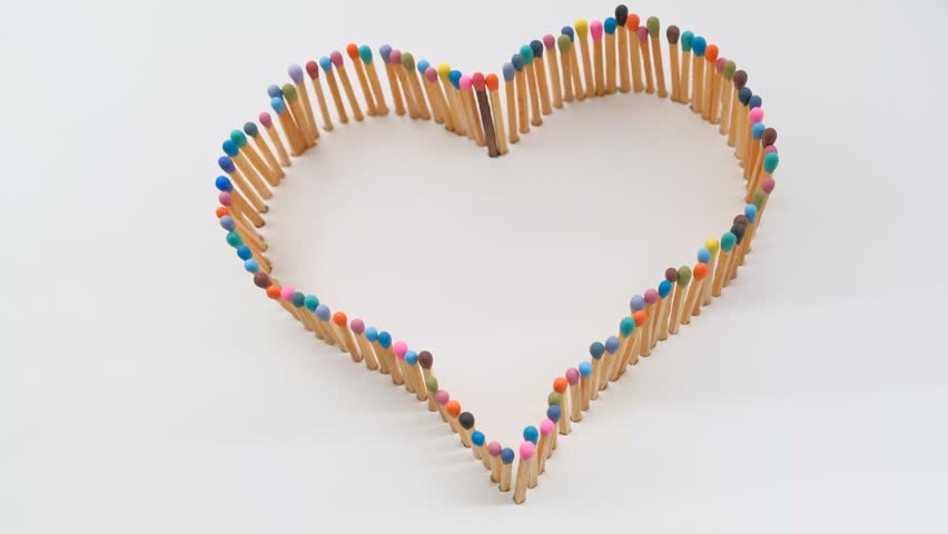 a heart shape made of multicolored matchsticks