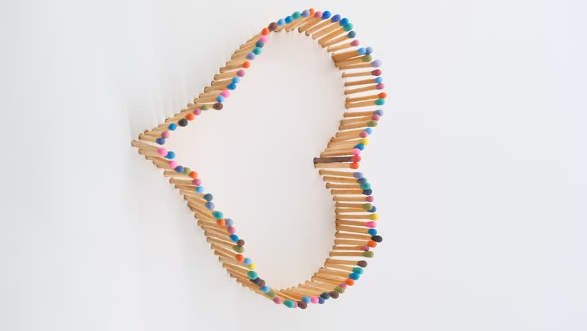 a heart shape made of multicolored matchsticks