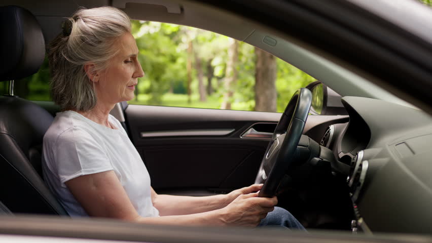 Despair stressed crying unhealthy Caucasian elderly aged senior woman female mature car driver auto owner grandmother lean on steering wheel pain traffic accident problem trouble in automobile at city