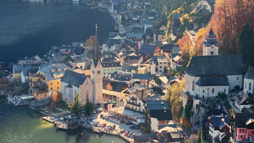 Fly over picturesque village of Hallstatt nestled in the Austrian Alps. Aerial tele shot of Evangelical Parish Church and old town in Hallstatt, Austria