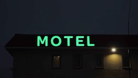 Motel rooftop LED volumetric sign that changes colors at night. Windows of top floor of building. Road-house horizontal signboard glowing in darkness, attracts tourists. Hotel is waiting for visitors - Powered by Shutterstock - Get 15% off with code: PIKWIZARD15