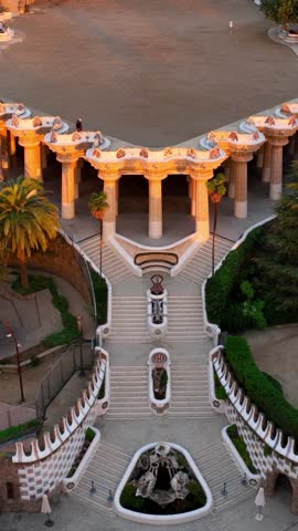 vertical video: Park Guell aerial shot at sunrise, tourist landmark in Barcelona. Antonio Gaudi architecture. Dawn in Barcelona park Guell, Spain. High quality FullHD footage