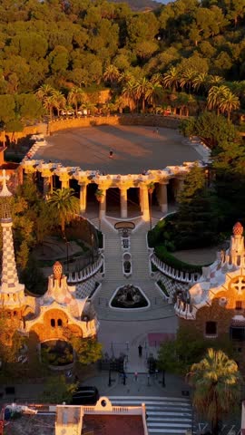 vertical video: famous Barcelona tourist spot Park Guell, aerial shot at sunrise, tourism in Barcelona. Antonio Gaudi architecture. Dawn in Barcelona park Guell, Spain. High quality FullHD footage