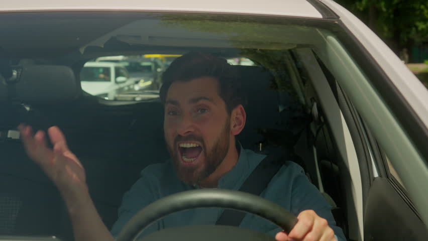 Caucasian man guy businessman driving car in city stuck traffic jam urban road transport problem accident angry aggressive mad furious male driver transport stressful drive automobile shouting scream