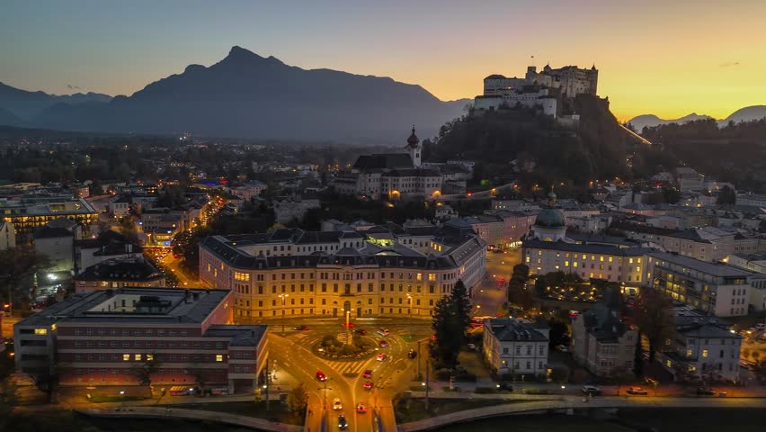 Breathtaking sunset over Salzburg, Austria, with stunning views of the fortress, historic buildings, and beautiful mountains. Aerial panoramic evening view of Salzburg. 4K HDR