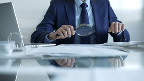 Businessman analyzing financial data with magnifying glass and calculator, conducting audit or review in office. Audit and taxes theme in business - Powered by Shutterstock - Get 15% off with code: PIKWIZARD15