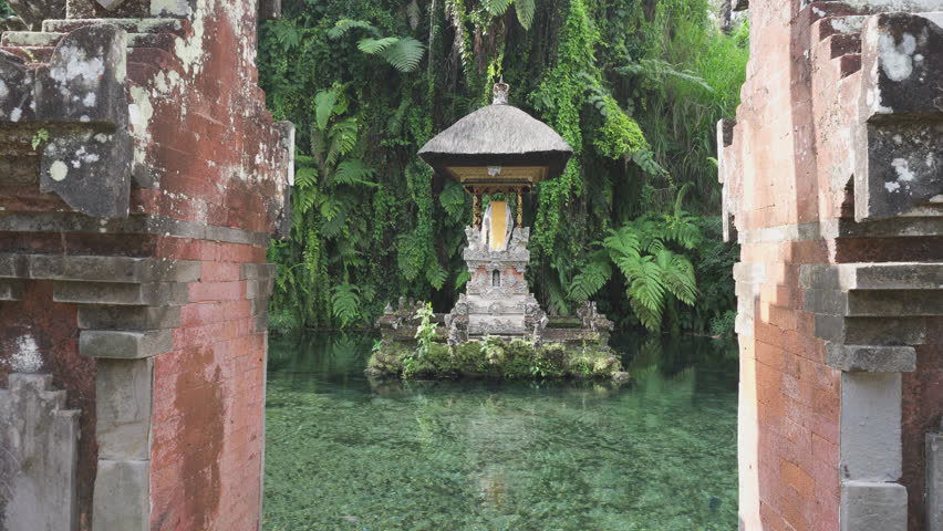 Awesome view of a pond at a Hindu Balinese water temple in Bali, Indonesia. The holy spring water arises from the ground. The temple pond is a popular tourist attraction of Asia.