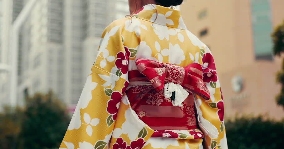 Woman, back and walking in city of Japan, traditional kimono and asian heritage or culture. Female person, yukata dress and outdoor commute on vacation, urban holiday and journey for sightseeing
