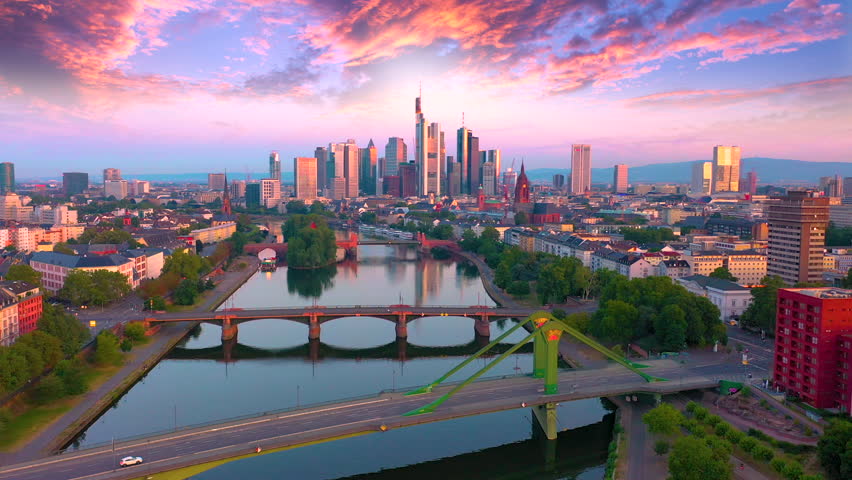 Frankfurt Aerial Flight through Frankfurt am Main, Germany. Skyline. New Skyscrapers. Urban Canyon in Sunset or Sunrise Light. Aerial Pedestal in Establishing Night Drone Shot. Glowing street lights