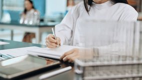 Laboratory, hands and woman writing notes, results or studying for test at Japanese medical college. Science, education and university student in class with notebook, pen and research ideas for exam. - Powered by Shutterstock - Get 15% off with code: PIKWIZARD15