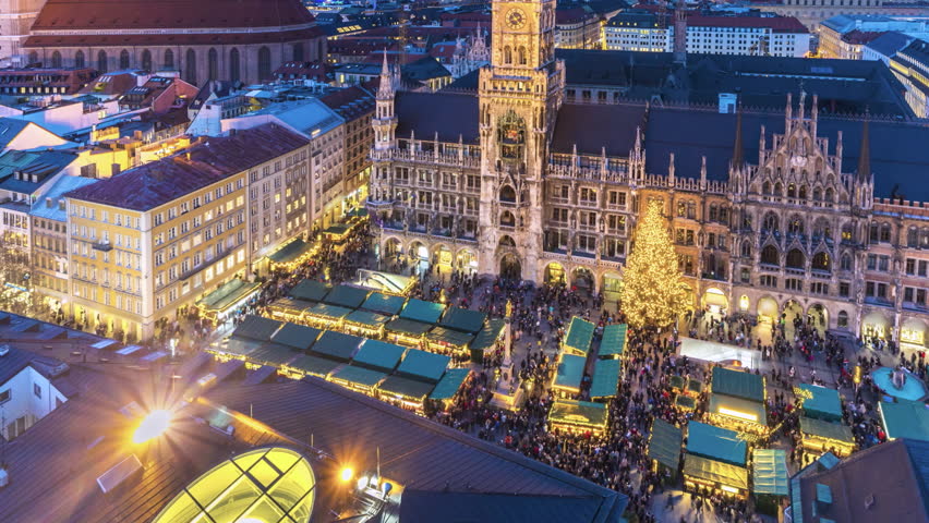 Marienplatz Munich at winter with munich christmas market view from top time lapse from day to night, people walking shopping in city centre marienplatz sqaure in front Frauenkirche church town hall.