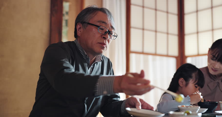 Grandfather, Japanese family and child at lunch for food, retirement or bonding together for eating. People, girl and home for healthy meal, diet and nutrition in dining room at table with senior man
