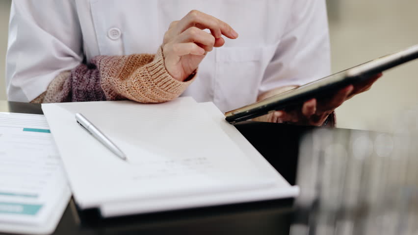 Laboratory, science and writing notes of Japanese person with research, study checklist and medical report. Planning, worker and hospital with healthcare and pharmaceutical job with paperwork