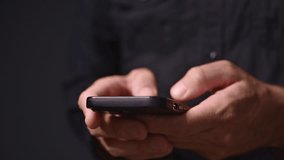 Closeup of male hands using mobile phone in dark room, man typing text message on smartphone, 4K with selective focus - Powered by Shutterstock - Get 15% off with code: PIKWIZARD15