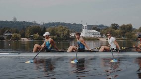 Rowing team training. Side view of 4 young caucasian male rowers resting, during a rowing practice, athlete sitting in a boat in the river Dnipro, calm water in autumn 4k footage - Powered by Shutterstock - Get 15% off with code: PIKWIZARD15