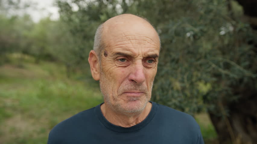 Elderly Bald Man Makes a Gross Face After Eating Bad Food In Nature