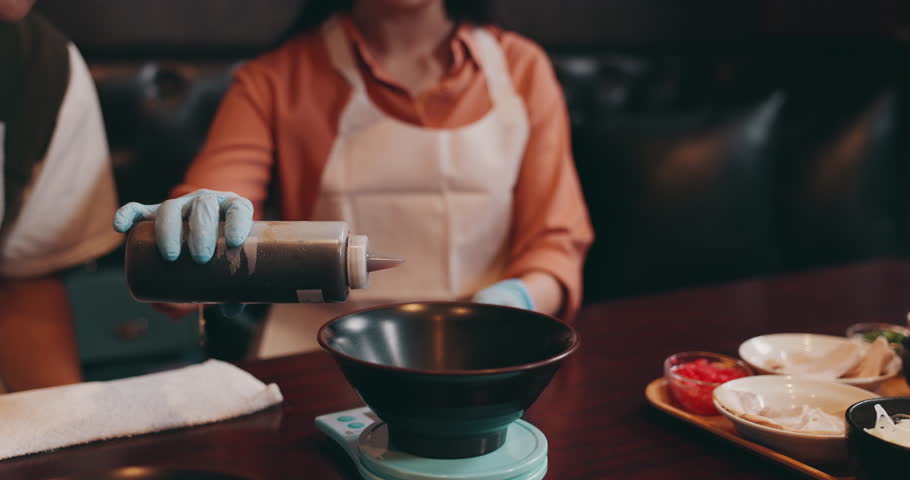 Hands, Japanese woman and soy sauce for healthy meal, food and traditional cuisine with bowl. Female person, serving and dinner as culinary culture, diet or preparing dish in Asian restaurant or cafe