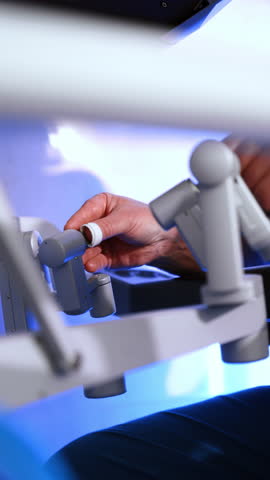 Male hands manipulating the robotic arms. Close up. Operating the modern surgical system to perform minimal invasive surgery. Vertical video.