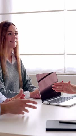 Vertical HD video of happy smiling millennial couple handshaking with senior female real estate agent meeting in the office after signing deal or contract.