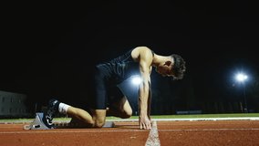 Strong Young Man Starting a Race From Track Starting Blocks Position on a Dark Stadium in the Evening. Cinematic Portrait of a Fit Male Sprint Runner Participating in a Competition - Powered by Shutterstock - Get 15% off with code: PIKWIZARD15