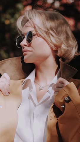 A professional blonde model posing for the camera. Autumn fashion. The trend of the season. Vertical format for the phone.