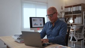 Senior manager experiencing neck pain while working on a laptop in an office setting, highlighting workplace discomfort - Powered by Shutterstock - Get 15% off with code: PIKWIZARD15