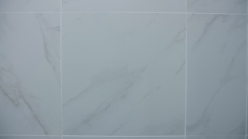 New ceramic light tiles on the bathroom wall