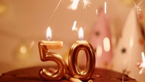 50 shape numbers golden candles and sparklers in a chocolate Birthday cake. A homely atmosphere of a happy Birthday party. Garlands and lights create comfort and warmth - Powered by Shutterstock - Get 15% off with code: PIKWIZARD15