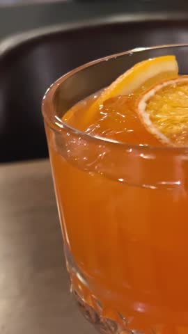 orange and alcohol drink in a beautiful glass in a restaurant drink through a straw