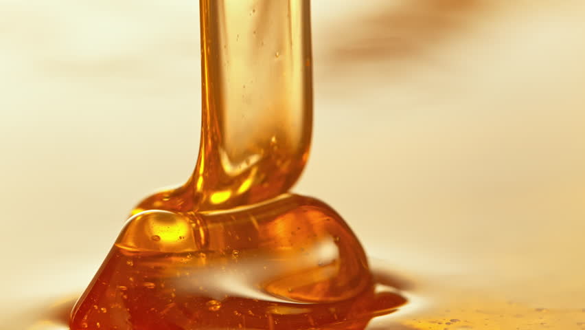 Super Slow Motion Detail Shot of Pouring and Layering Premium Honey at 1000fps.