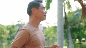 Asian senior elderly sportsman running exercise outdoors in the garden. Attractive mature older man jogger feel happy and relax, practice workout warm up for health care in public park during sunset. - Powered by Shutterstock - Get 15% off with code: PIKWIZARD15