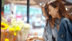 4K Happy Asian woman family enjoy urban lifestyle shopping together at department store. Mature mother and adult daughter choosing bouquet of flowers during buying food and grocery in supermarket. - Powered by Shutterstock - Get 15% off with code: PIKWIZARD15