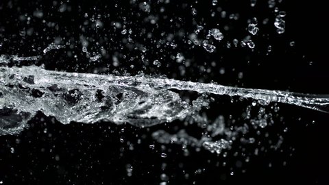 Pouring water and making splashes on black background shooting with high speed camera, phantom flex.