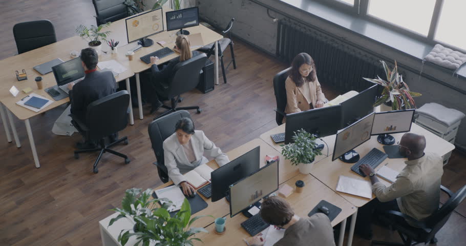 Top view of people office employees working at desks in modern open space workplace. Career development and coworking center concept.