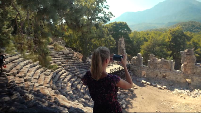 Summer Holidays Vacation Trip Adventure On Seacoast. Heritage Tourist Walking Along Trail On Greek Ancient Town. Tourist Walking On Mediterranean Sea. Girl Exploring Old Town In Turkey. Tourist Photo