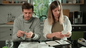 Worried couple calculating domestic bills and counting remaining money, Worried man and woman sitting at kitchen table and planning family budget. Concept of rising costs in households - Powered by Shutterstock - Get 15% off with code: PIKWIZARD15