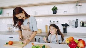 Joyful Cooking Moments In a bright, modern kitchen, a woman and her child joyfully prepare fresh ingredients together, sharing smiles and creating precious memories through cooking - Powered by Shutterstock - Get 15% off with code: PIKWIZARD15