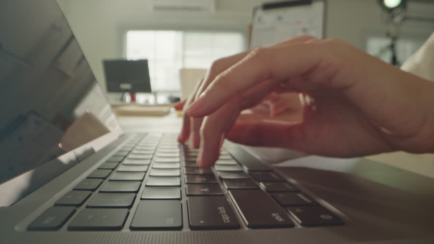 Macro close up of Unknown woman hands typing on computer keyboard in office. Dolly shot fingers pressing buttons on laptop. Programming, text chat online messaging and send emails marketing business.