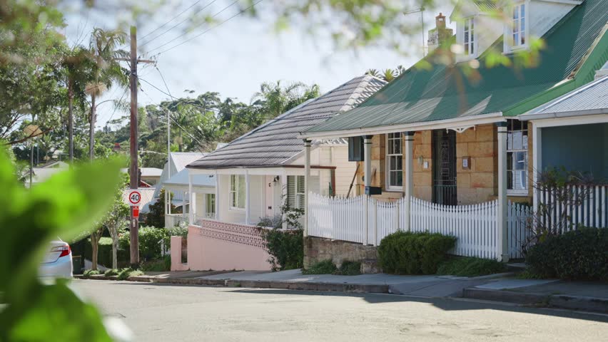 Row of typical simple colorful houses in residential neighborhood in Sydney. Traditional city private houses with front porches in quiet and peaceful street during springtime in sunny Australia