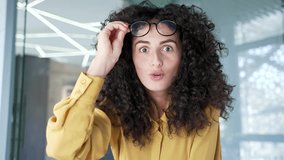 Webcam view. Surprised happy young businesswoman reading great news looking at camera on laptop screen in office. Excited shocked adult woman celebrating success, takes off glasses in surprise. Wow - Powered by Shutterstock - Get 15% off with code: PIKWIZARD15