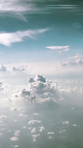 Vertical Shot of a Space Rocket or Nuclear Missile Launching Through the Fluffy White Clouds into a Blue Sky Seen From Above with Long Exhaust Trail