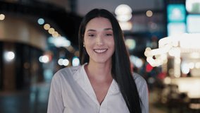 Young Woman Smiling in Urban Evening Setting With City Lights and Vibrant Atmosphere in the Background - Powered by Shutterstock - Get 15% off with code: PIKWIZARD15