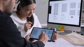 UX UI designer testing prototype on a tablet, discussing and brainstorming on wireframes for a website and mobile app prototype, in the concept of website and mobile application design concept. - Powered by Shutterstock - Get 15% off with code: PIKWIZARD15