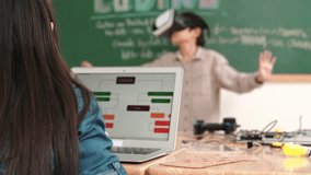 Boy wearing VR headset to enter metaworld at table with electronic board while girl coding system. Group of diverse student working together to develop program and writing engineering code. Pedagogy. - Powered by Shutterstock - Get 15% off with code: PIKWIZARD15