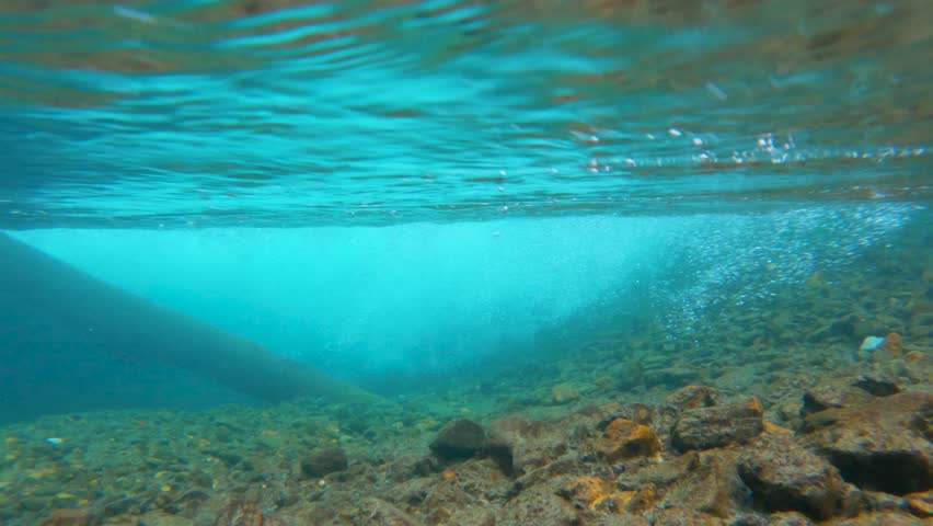 4k under water shot of the stream in the mountains at Manali in Himachal Pradesh, India. Camera goes under the water of the mountain stream. Natural background.
