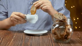 Hand takes italian cantucci cookies with almond and cranberries from a glass jar and dunks it into an espresso cup. High quality 4k footage - Powered by Shutterstock - Get 15% off with code: PIKWIZARD15